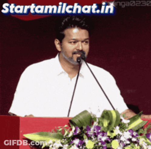 Man Speaking Into Microphone At Podium With Starttamilchat.in GIF
