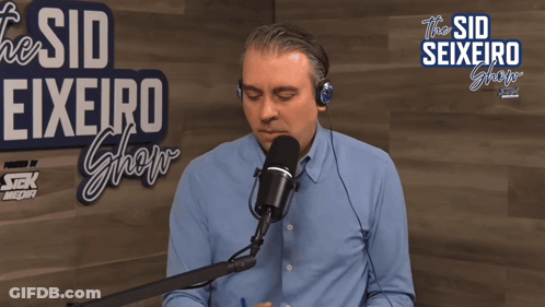 Man Speaking Into Microphone At The Sid Seixeiro Show Sign GIF