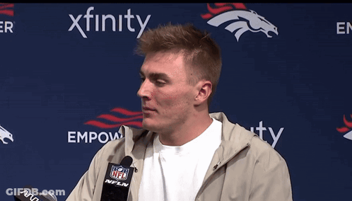 Man Speaking Into Microphone In Front Of Empower Banner GIF