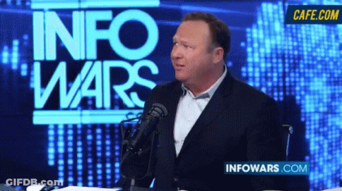 Man Speaking Into Microphone In Front Of Info Wars Screen GIF