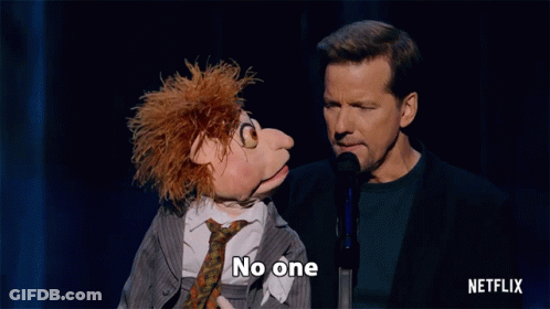 Man Speaking Into Microphone Next To Puppet Saying Cares GIF