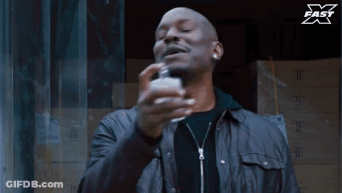 Man Spraying Perfume Bottle With X Fast Logo GIF