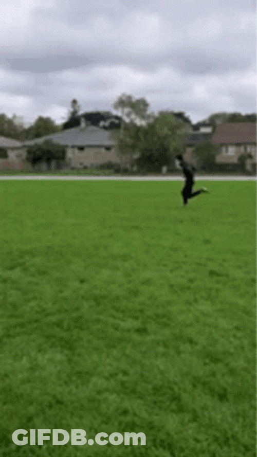 Man Sprinting Across Grassy Field GIF
