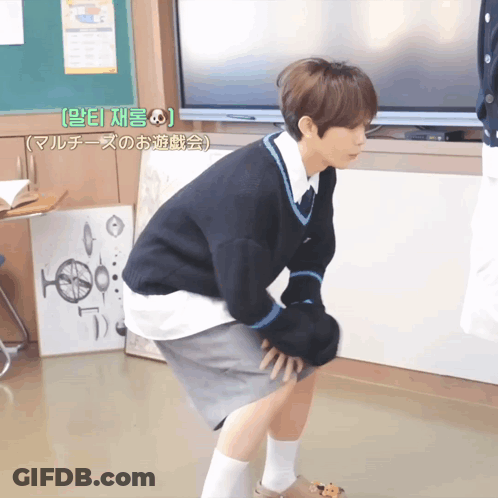 Man Squatting At Green Board With Chinese Writing GIF