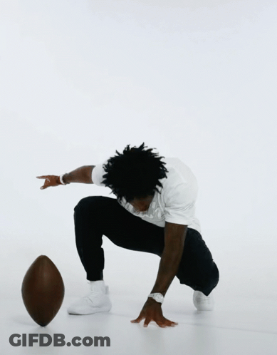 Man Squatting Holding Wilson Football GIF