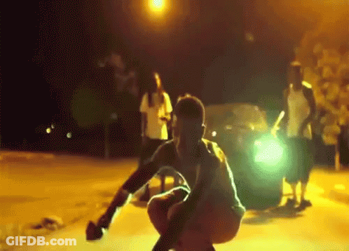 Man Squatting In Front Of Car With Light GIF