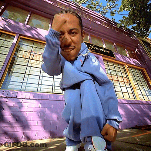 Man Squatting In Front Of Purple Jewelry Building GIF