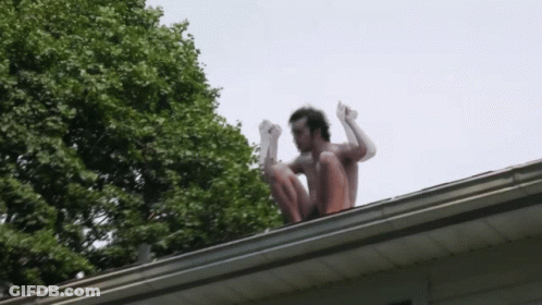 Man Squatting On Roof With Arms Up GIF