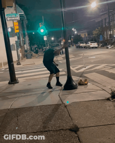 Man Squatting On Sidewalk At Stevens Ave GIF