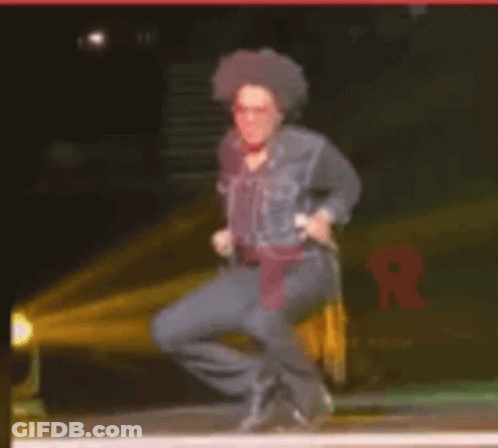 Man Squatting On Stage With Microphone GIF