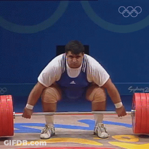 Man Squatting With Barbell In Front Of Sydney 2002 Sign GIF