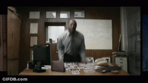 Man Standing At Desk With Computer And Phone GIF