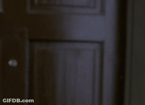 Man Standing At Window With Blinds GIF