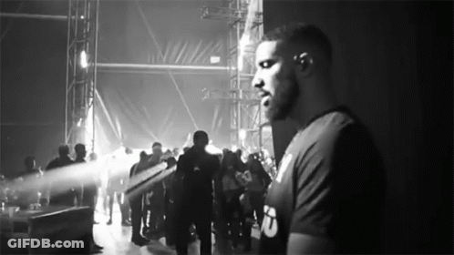 Man Standing Before Crowd In Black And White GIF