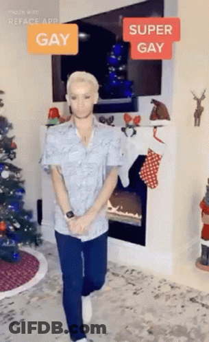 Man Standing By Fireplace And Christmas Tree GIF