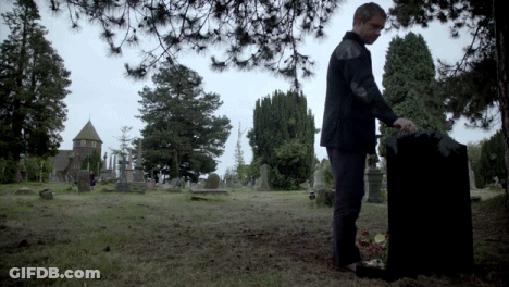 Man Standing By Grave In Cemetery GIF