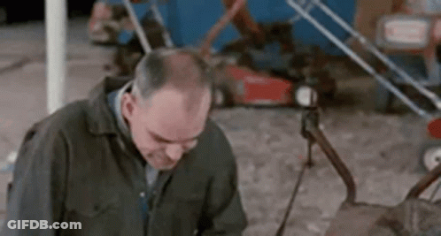 Man Standing By Lawn Mower Looking Down GIF