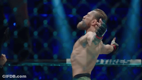 Man Standing In Boxing Ring With Arms Out GIF