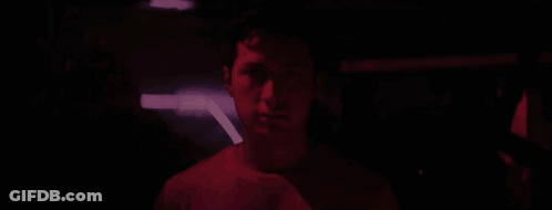 Man Standing In Crowd In Dark Room GIF