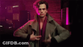 Man Standing In Dark Room Holding Jacket And Sword GIF
