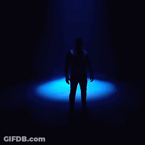Man Standing In Dark Room With Blue Lights GIF