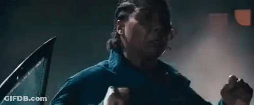 Man Standing In Dark Room With Hands In Air GIF