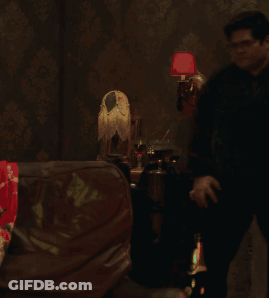 Man Standing In Dark Room With Red Lamp GIF