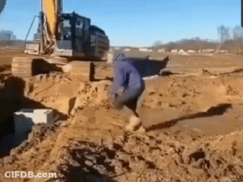 Man Standing In Dirt Front Of Excavator GIF