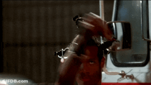 Man Standing In Front Of Ambulance With Arm Raised GIF