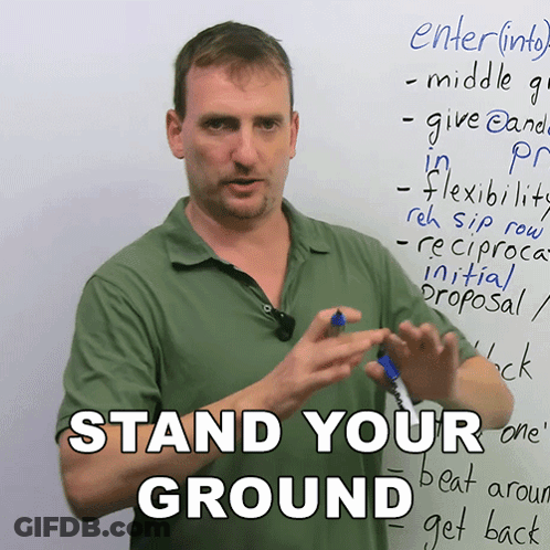 Man Standing In Front Of Board Saying Stand Your Ground GIF