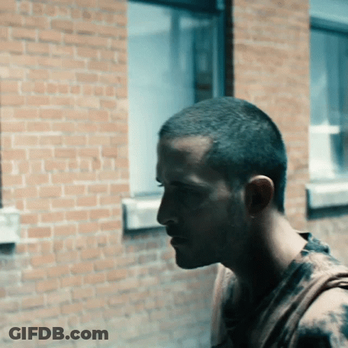 Man Standing In Front Of Brick Building GIF