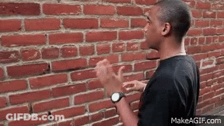 Man Standing In Front Of Brick Wall GIF