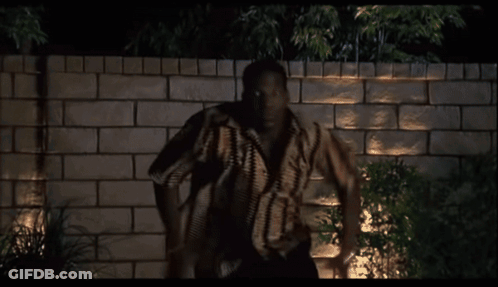 Man Standing In Front Of Brick Wall At Night GIF