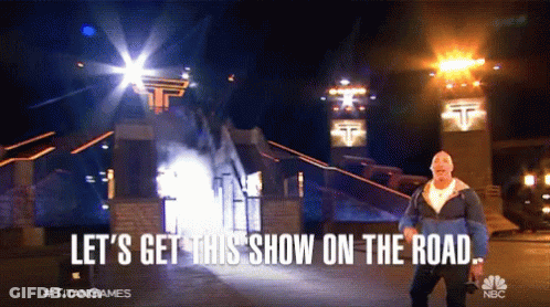 Man Standing In Front Of Building Saying Let's Get This Show On The Road GIF
