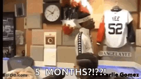 Man Standing In Front Of Clock And Jersey Saying 52 GIF