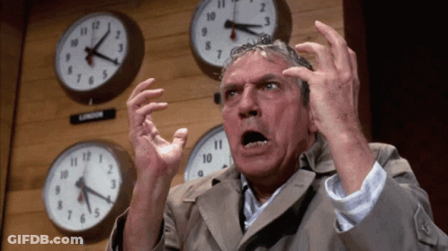 Man Standing In Front Of Clocks Including London GIF