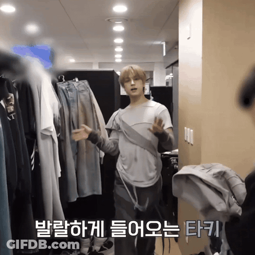 Man Standing In Front Of Closet With Foreign Language On Wall GIF