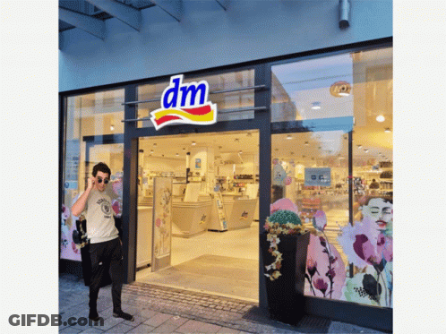 Man Standing In Front Of DM Store GIF