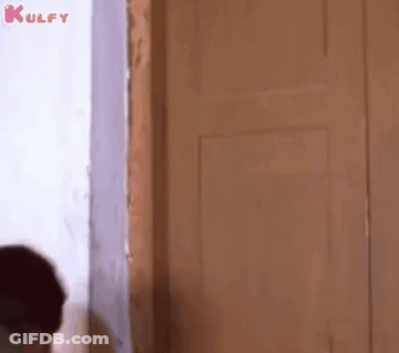 Man Standing In Front Of Door Looking Out GIF