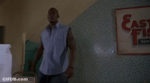 Man Standing In Front Of East Fish Sign GIF