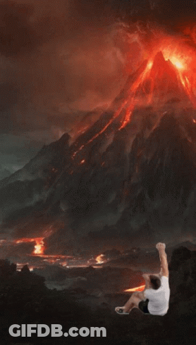 Man Standing In Front Of Erupting Volcano GIF