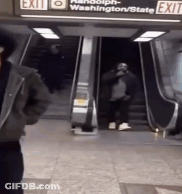 Man Standing In Front Of Exit Escalator GIF