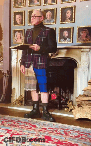 Man Standing In Front Of Fireplace With Pictures GIF