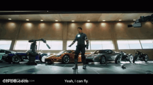 Man Standing In Front Of Garage Full Of Cars GIF