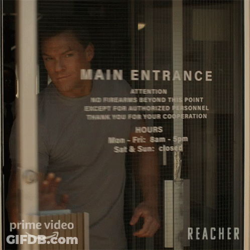 Man Standing In Front Of Glass Door Saying Main Entrance GIF