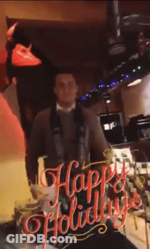 Man Standing In Front Of Happy Holiday Sign GIF