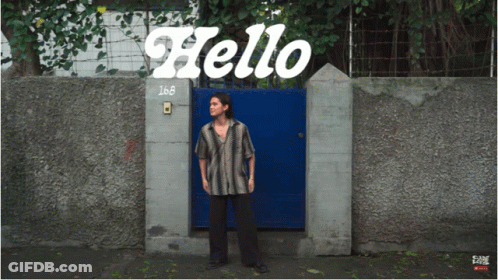 Man Standing In Front Of Hello Gate GIF