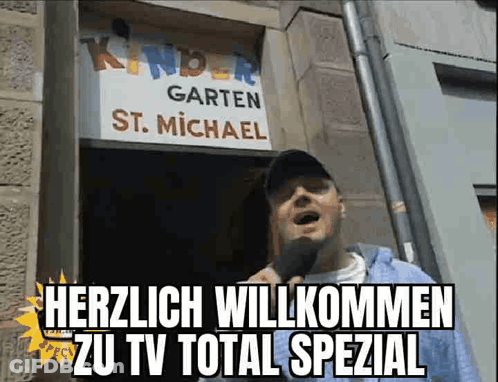 Man Standing In Front Of Kindergarten St. Michael Sign GIF