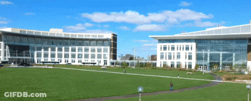 Man Standing In Front Of Large Building GIF