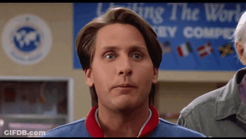 Man Standing In Front Of Leading The World Hockey Company Sign GIF